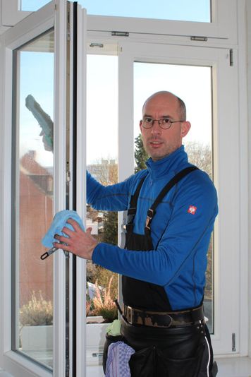 Mitarbeiter von Fensterreinigung Eric Patzen putzt ein Fenster